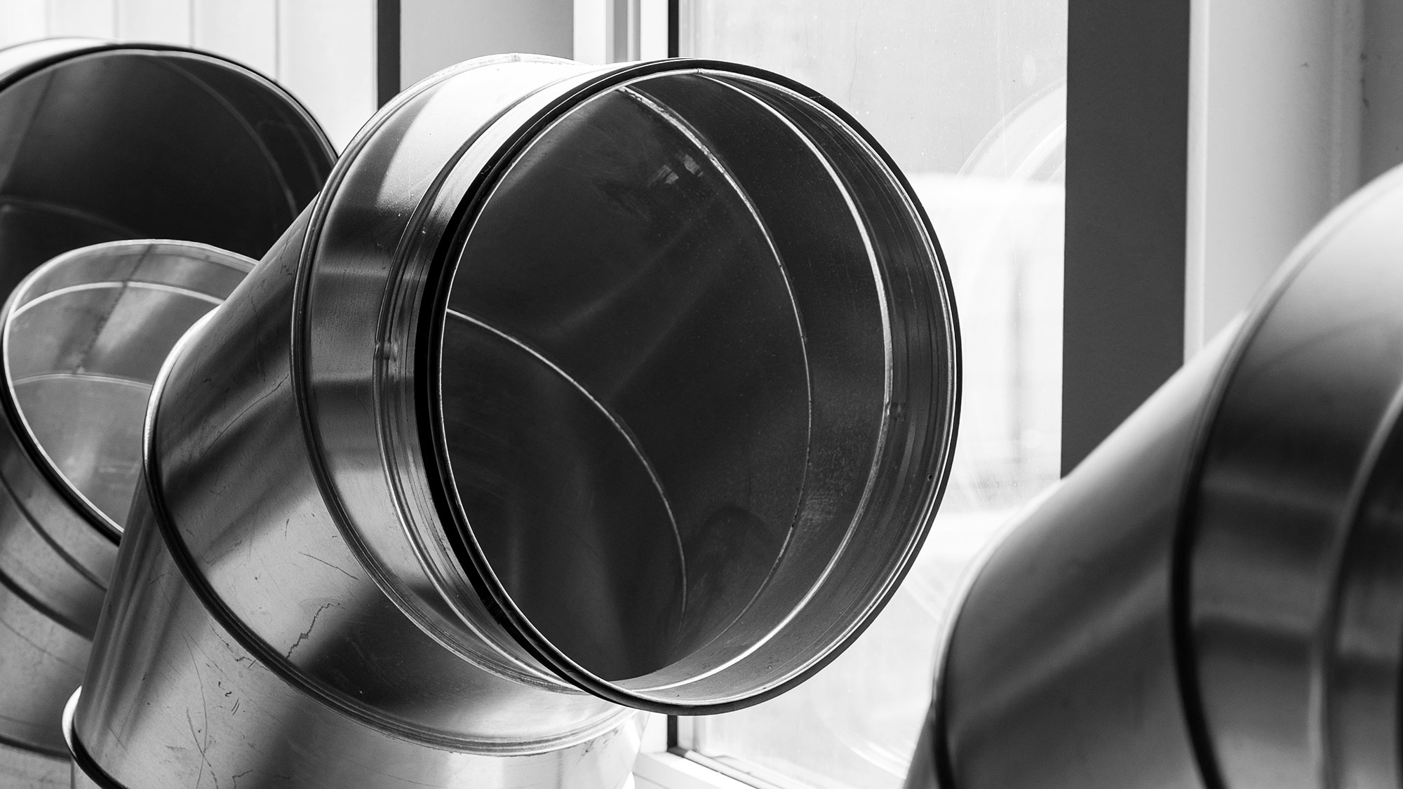 Einzelne Bauteile einer Klimaananlage stehen vor einem Fenster