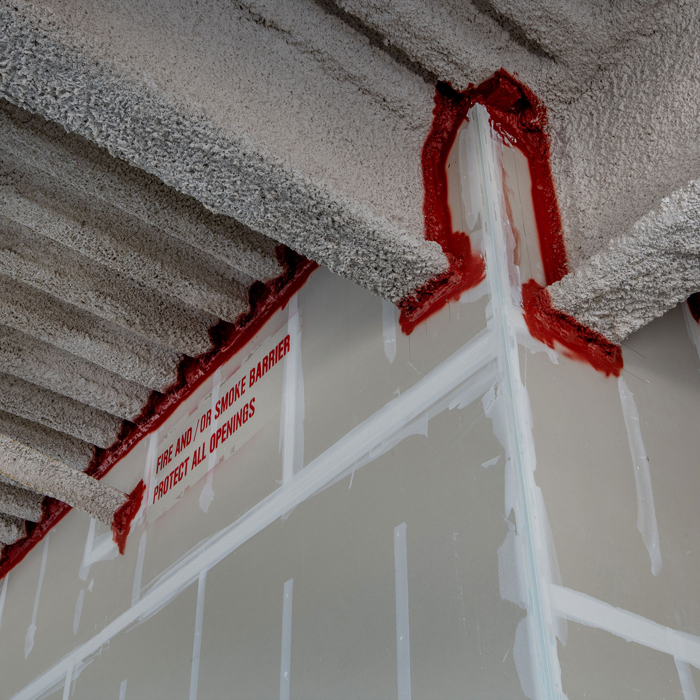 Man sieht Bauteile einer Decke und Verstrebungen aus Beton. In den Fugen ist eine spezielle Beschichtung angebracht, um zu verhindern, das Feuer zwischen diesen Bauteilen durchbrechen kann.
